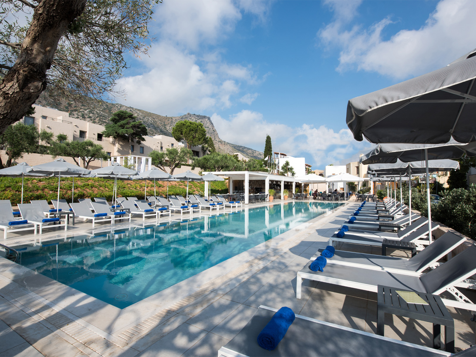 Relaxing poolside with sun loungers, hotel in Crete